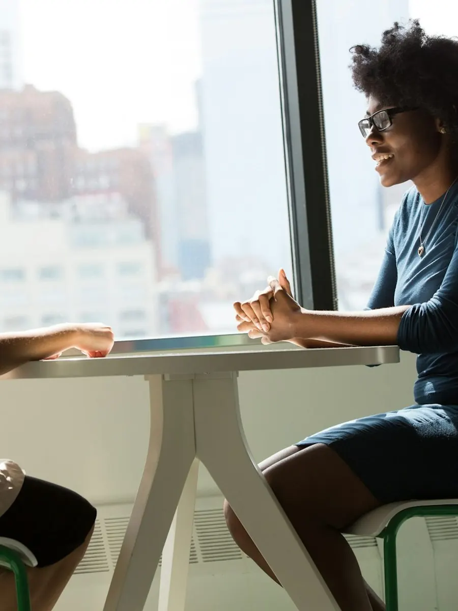 Two entrepreneurs in conversation by a window