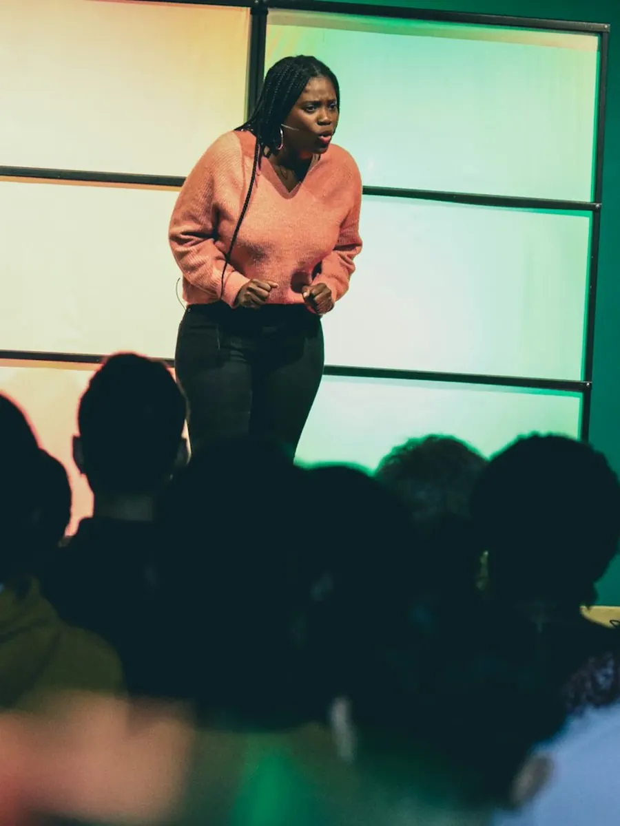 An entrepreneur on stage, pitching to a full room