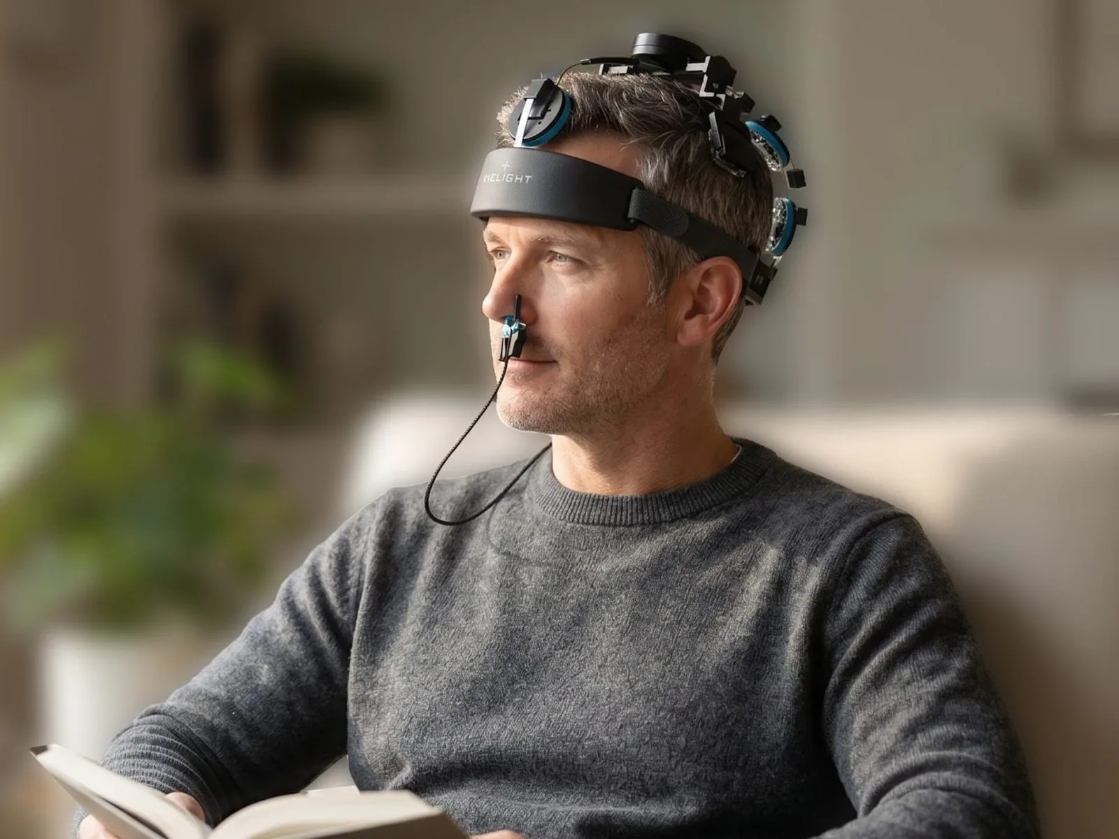 A man reading with the Vielight headset on, eyes on the page