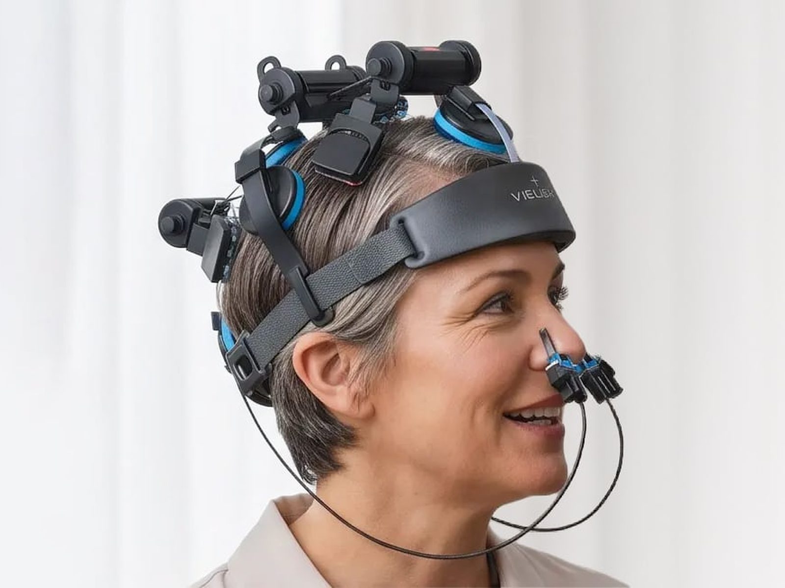 A woman wearing the Vielight headset, smiling